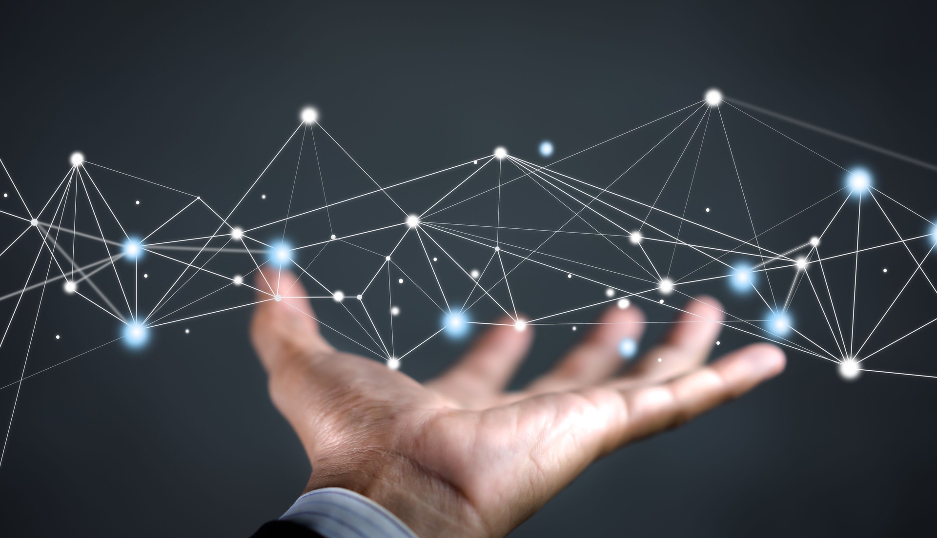 Hand of businessman on background holding connections system and global data exchanges. Business network connection concept.